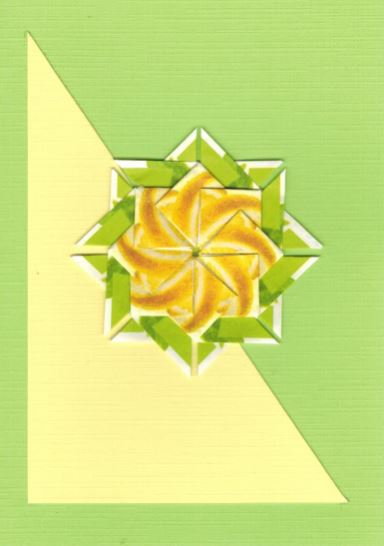 Lente kaart met spiraalrozet van lentekleuren op een driehoek geplaatst. <br>Deze rozet is gemaakt uit theezakjes van Pickwick green tea lemon.