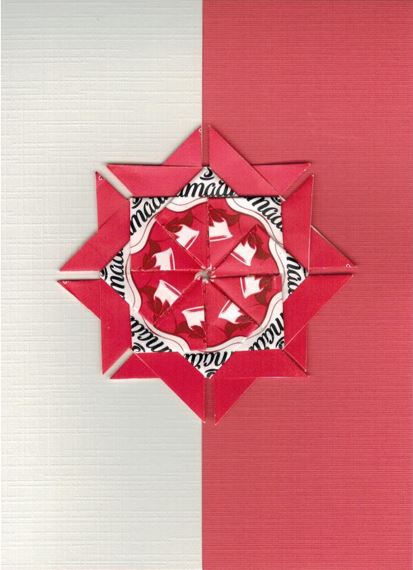Een Amarti wit rode love rozet met roze bladwijzer motief.<br>Deze rozet is gemaakt uit Amarti love theezakjes.