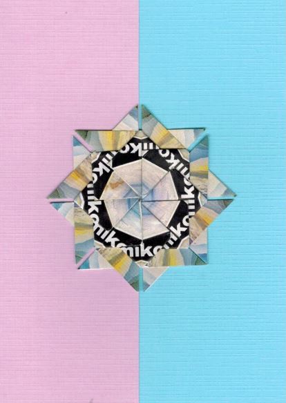 Een blauwe mix rozet op een kaart met bladwijzer motief. <br>Deze rozet is gemaakt uit Miko theezakjes.